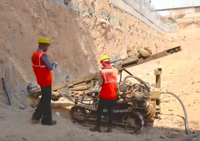 two construction workers using a drilling machine for diaphragm wall construction